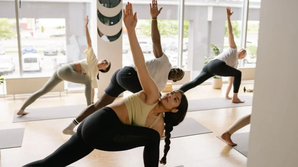 Группа на занятии йогой, выполняющая одинаковую позу